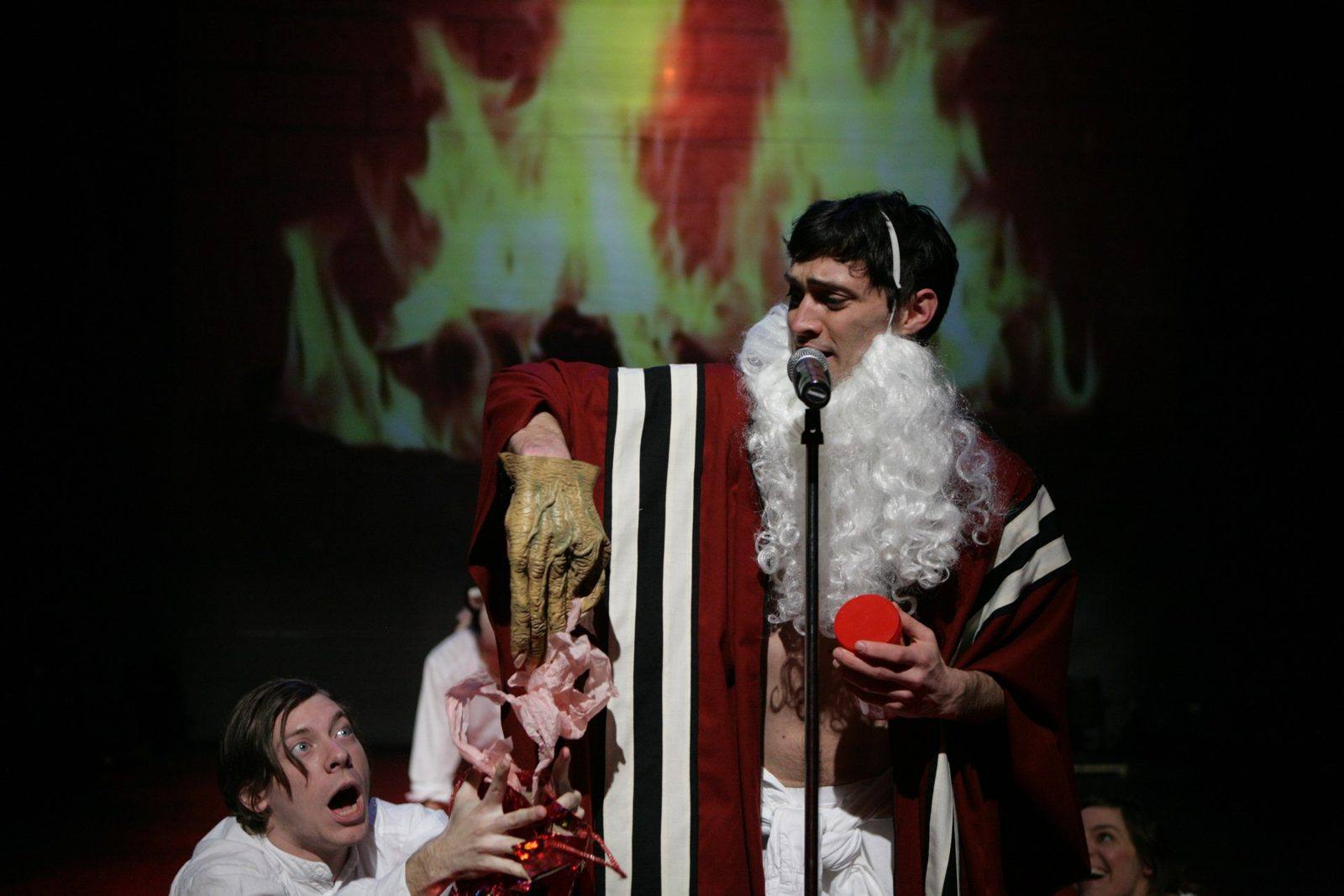 Haggadah: Moses in a cotton-ball beard and monster glove sings into a mic