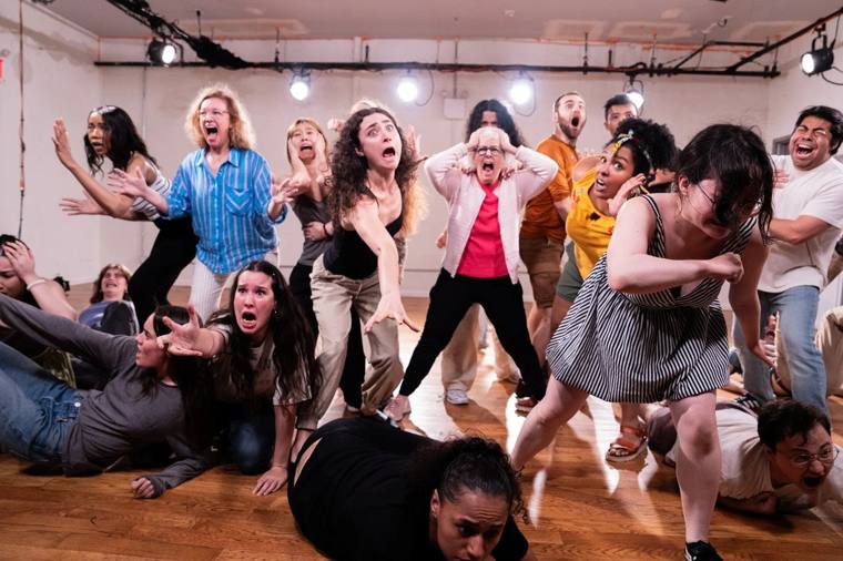 Winning Is Winning: a large cast screams and lunges toward the camera, some sprawled across a wooden studio floor